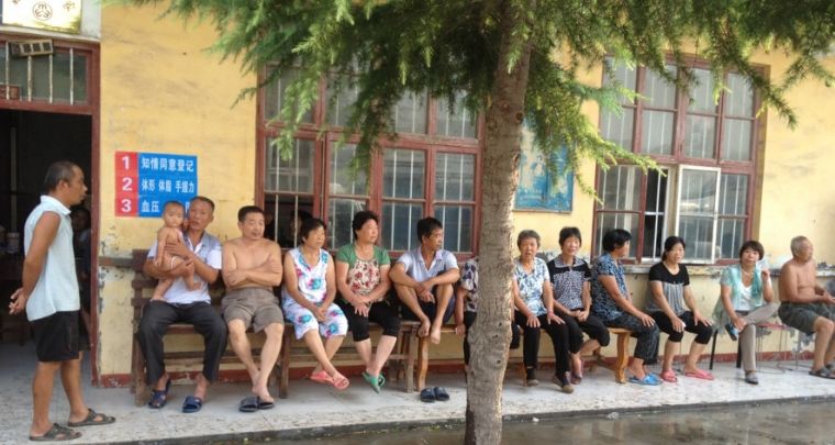 People sitting outside a health centre in China.