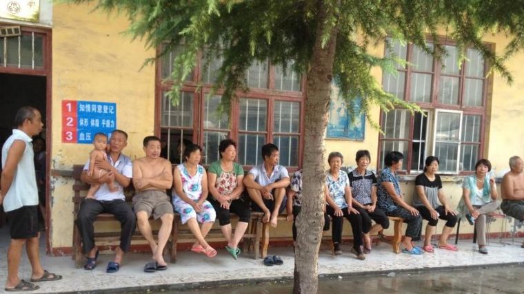 People sitting outside a health centre in China.