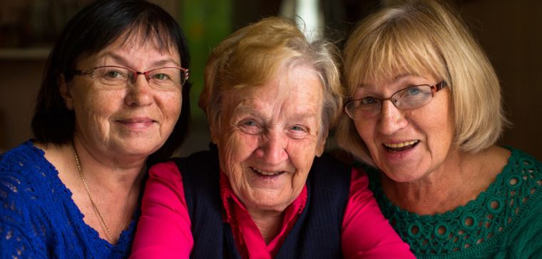 two middle aged and one older women all smiling.