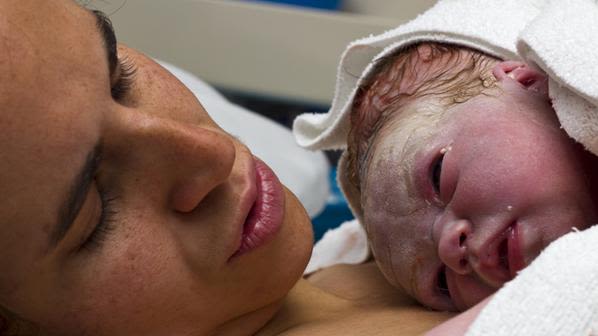 Mother cradling her newborn baby.